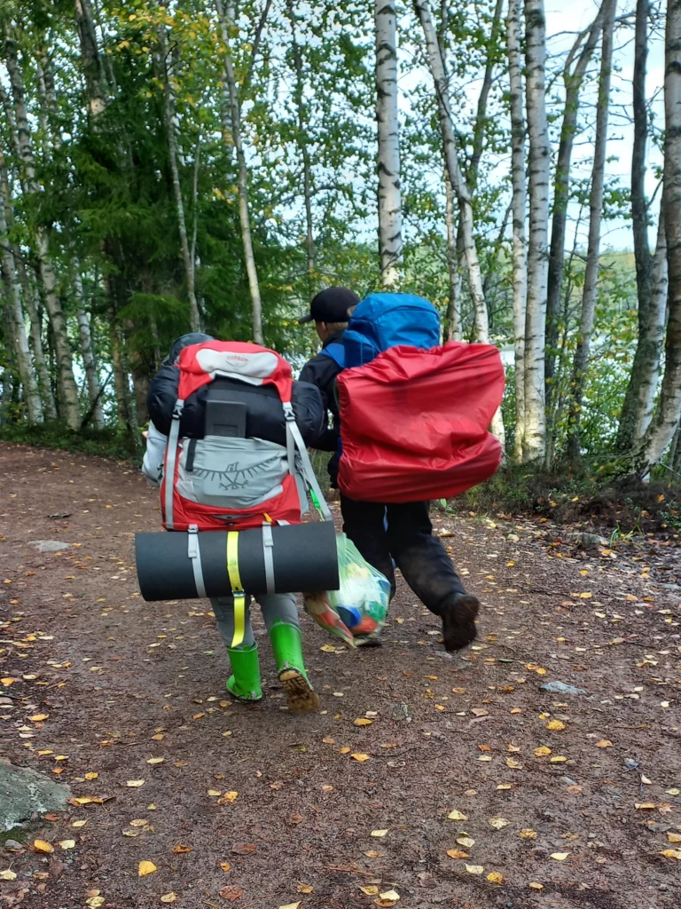 Kaksi tarpojaikäistä poikaa leveällä metsäpolulla