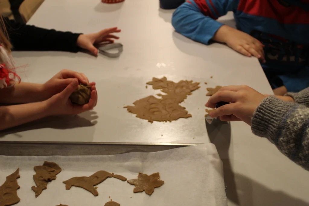 Neljän lapsen kädet leipomassa pipareita