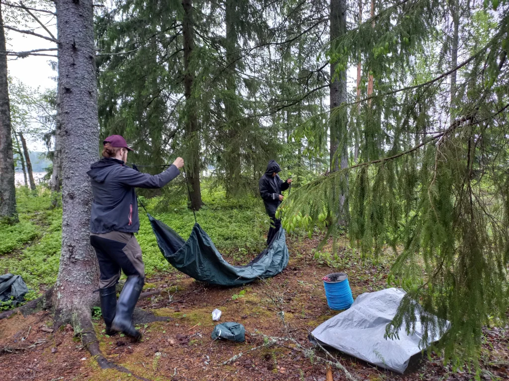 Mies ja poika ripustaa riippumattoa metsässä