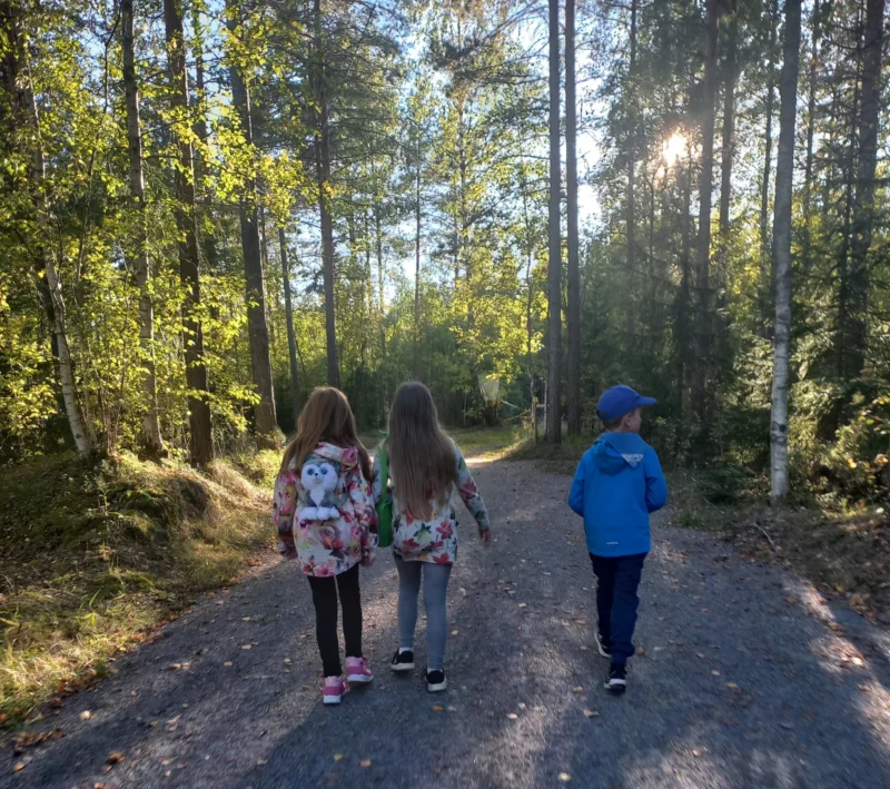Kolme lasta kuntopolulla metsässä
